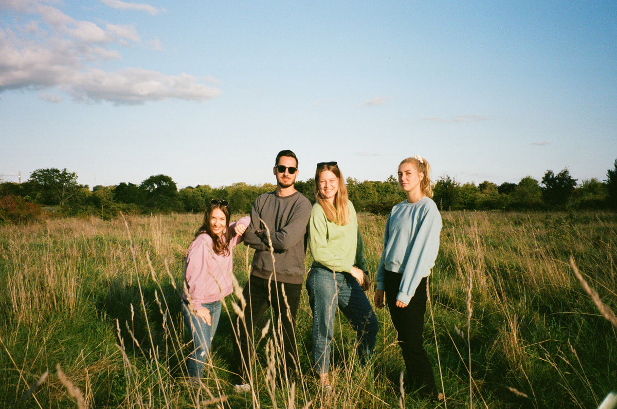 Vier Freunde in LATE 'N' LAZY Sweatshirts auf einer Wiese bei Wiesbaden